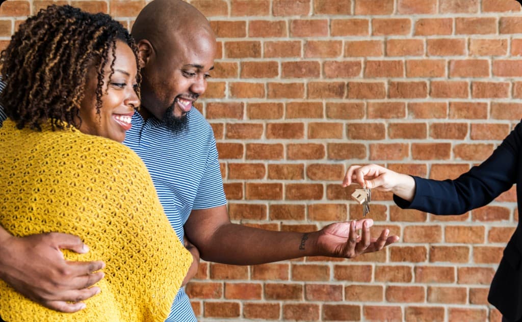 A couple receiving keys after completing a property transfer